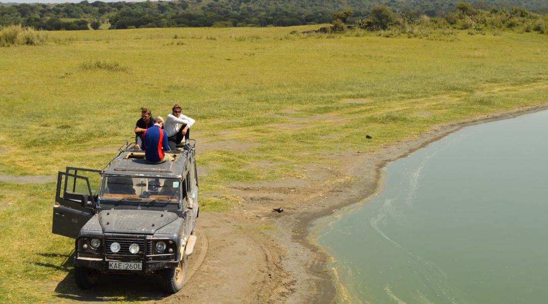 Volunteers sit on a car by a flamingo lake in Kenya Last-minute volunteers on project in Kenya